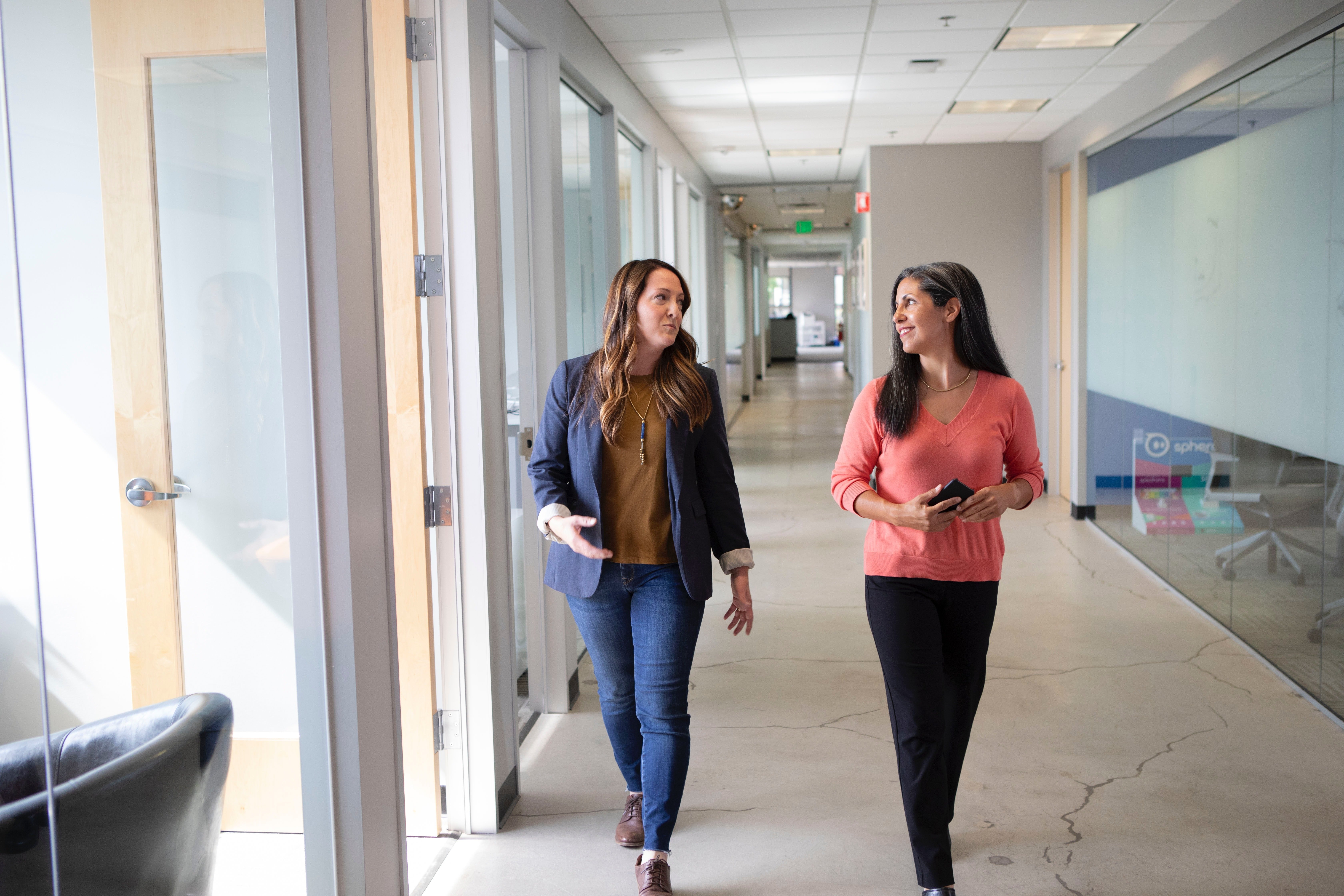 2 women talking in office hall