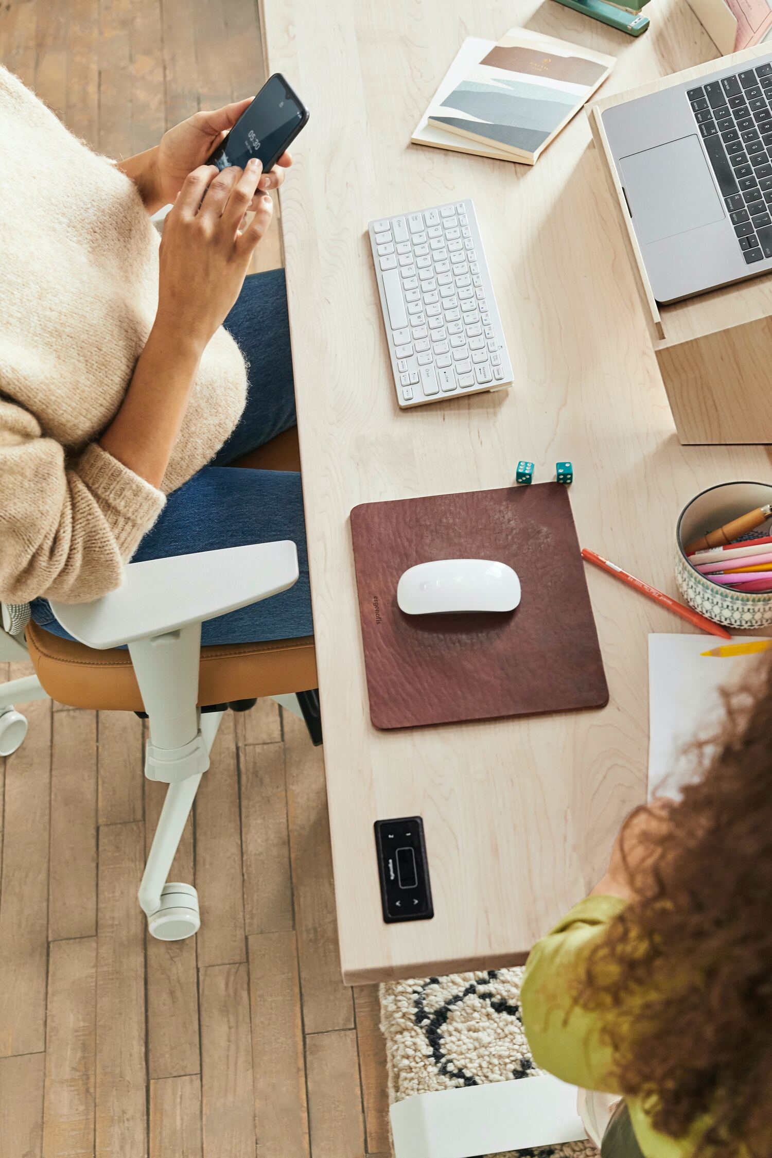 a woman sitting at a desk using a cell phone