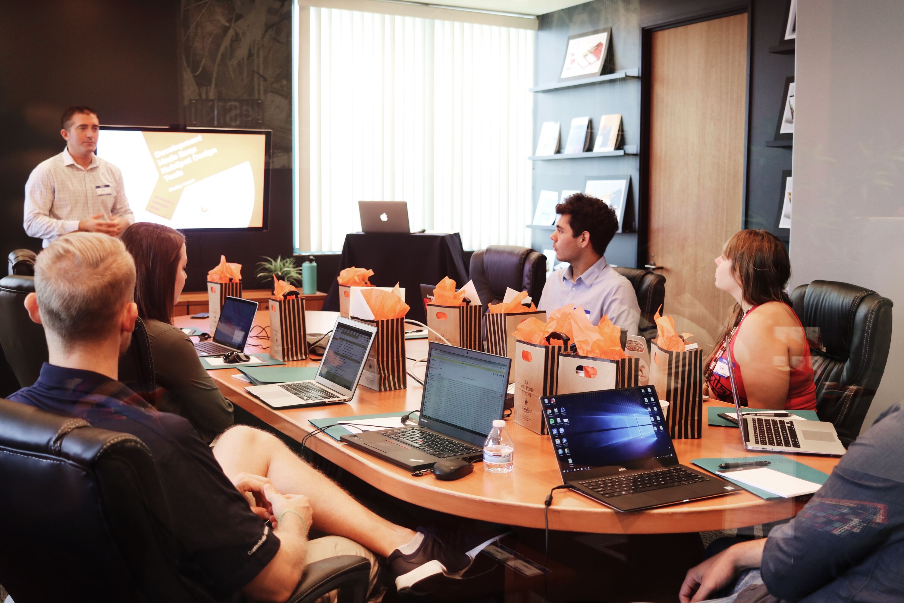 man standing in front of people sitting beside table with laptop